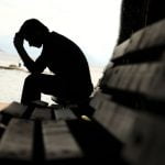 depressed young man sitting on the bench