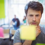 Close-up of male executive reading sticky notes