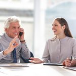 Cheerful man talking on phone and showing ok sign