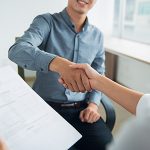 Smiling Asian businessman shaking partners hand