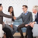 Smiling Business Partners Shaking Hands in Lounge