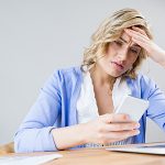 Stressed woman using mobile phone