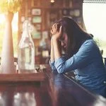 Young woman sitting in a cafe with her laptop, Stressful for wor