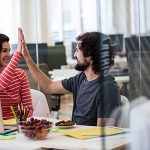 Male and female graphic designers giving high five to each other