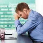 Upset young businessman in front of laptop