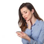 Troubled Woman Reading Bad News On Phone Touching Her Head In Mi