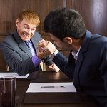 Two Businessmen Arm Wrestling in Modern Office